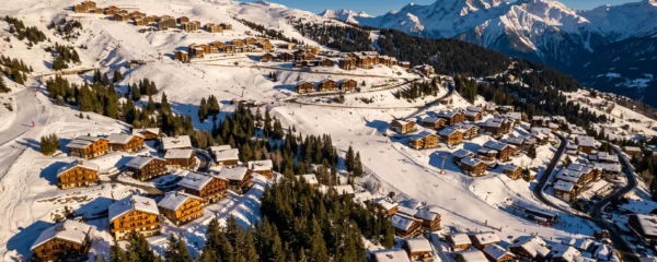 Wide view of Courchevel 1850 ski resort showing distinct neighbourhoods spread across the snowy mountainside with varying chalet densities and ski slope proximity